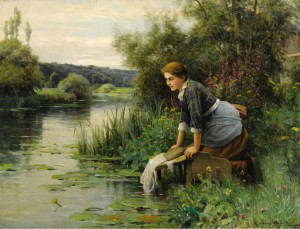 Woman washing clothes by a stream